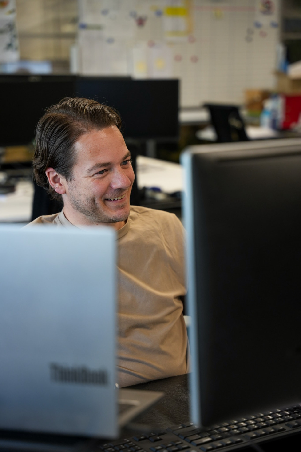 Medewerker achter beeldschermen in een kantooromgeving